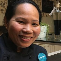 Photo of Chef Corazon Furuseth with herbs and greens in the background.